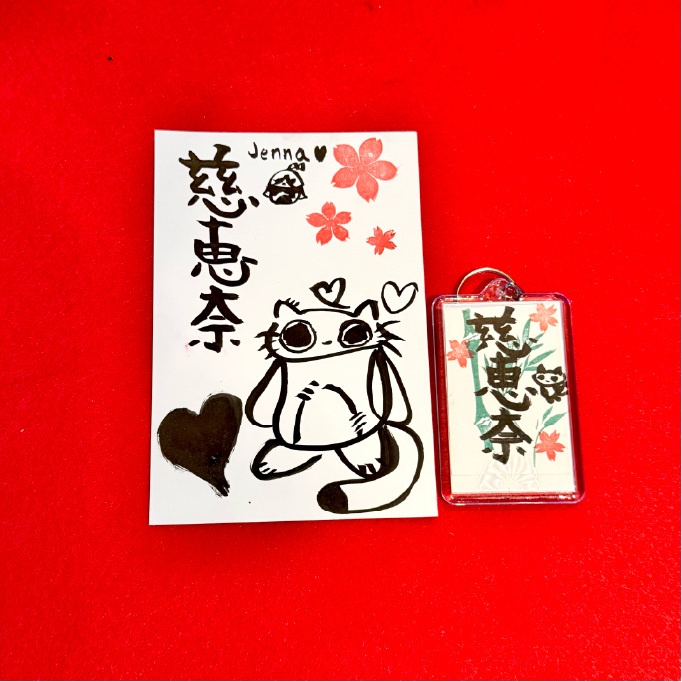 shodocafe7557 calligraphy postcard keychain jenna A personalized calligraphy postcard and keychain with the name ‘Jenna’ (慈恵奈) written in kanji at Shodocafe7557 in Roppongi, Tokyo. Includes sakura stamps and a cute cat illustration.