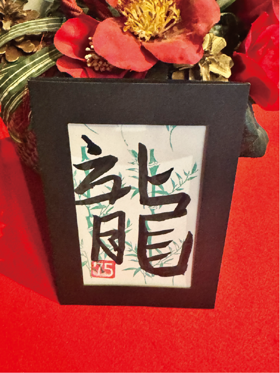 Calligraphy postcard featuring the kanji ‘ryu’ (龍), decorated with bamboo accents in a black frame at Shodocafe7557 in Roppongi, Tokyo.
