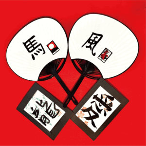 utiwa2 Two uchiwa fans featuring the kanji characters ‘馬’ (horse) and ‘風’ (wind) created during a summer calligraphy experience at Shodocafe7557 in Roppongi, Tokyo. Framed kanji art with sakura motifs included.
