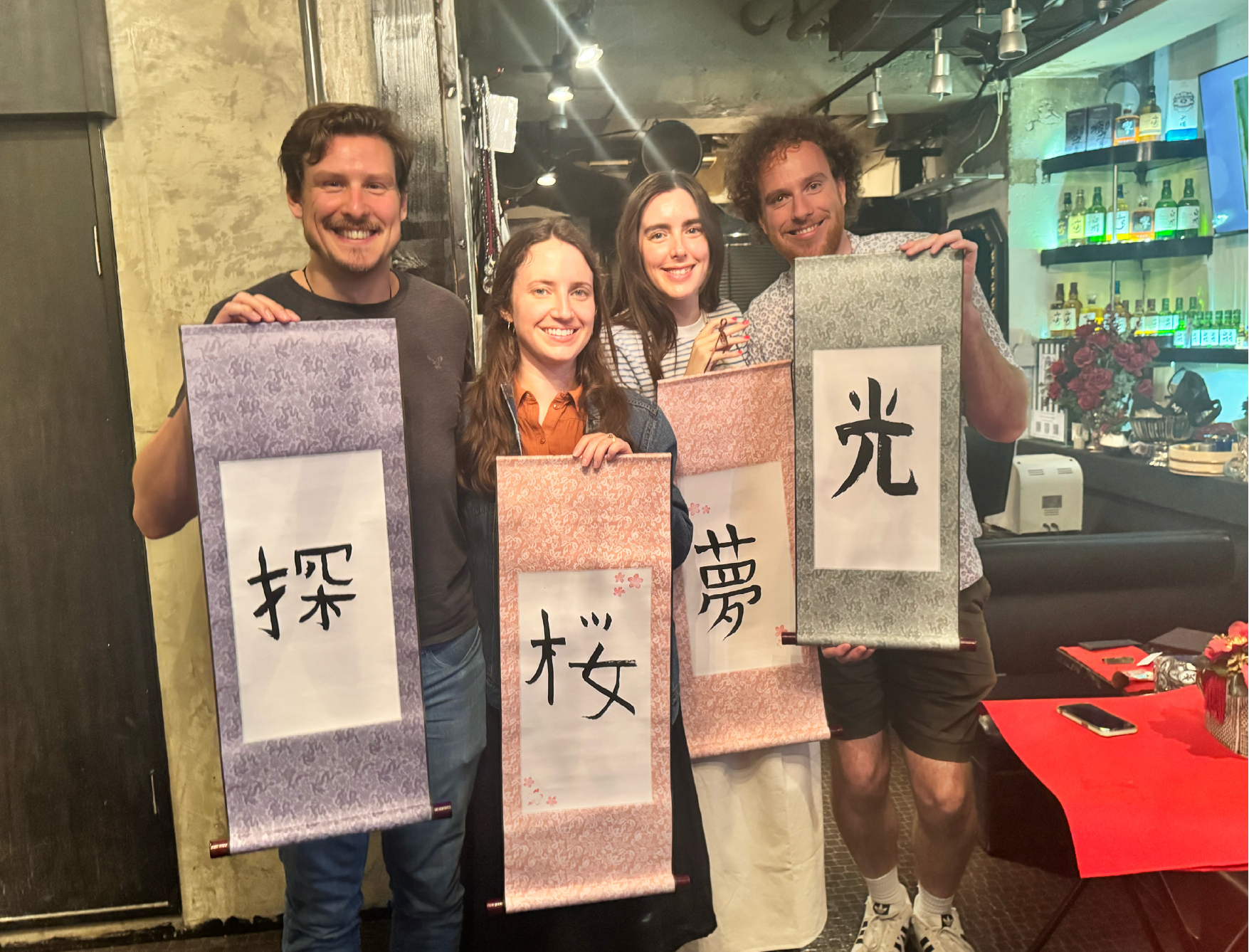 group kanji scrolls shodocafe7557 Four smiling guests holding custom kanji scrolls at Shodocafe7557, Roppongi