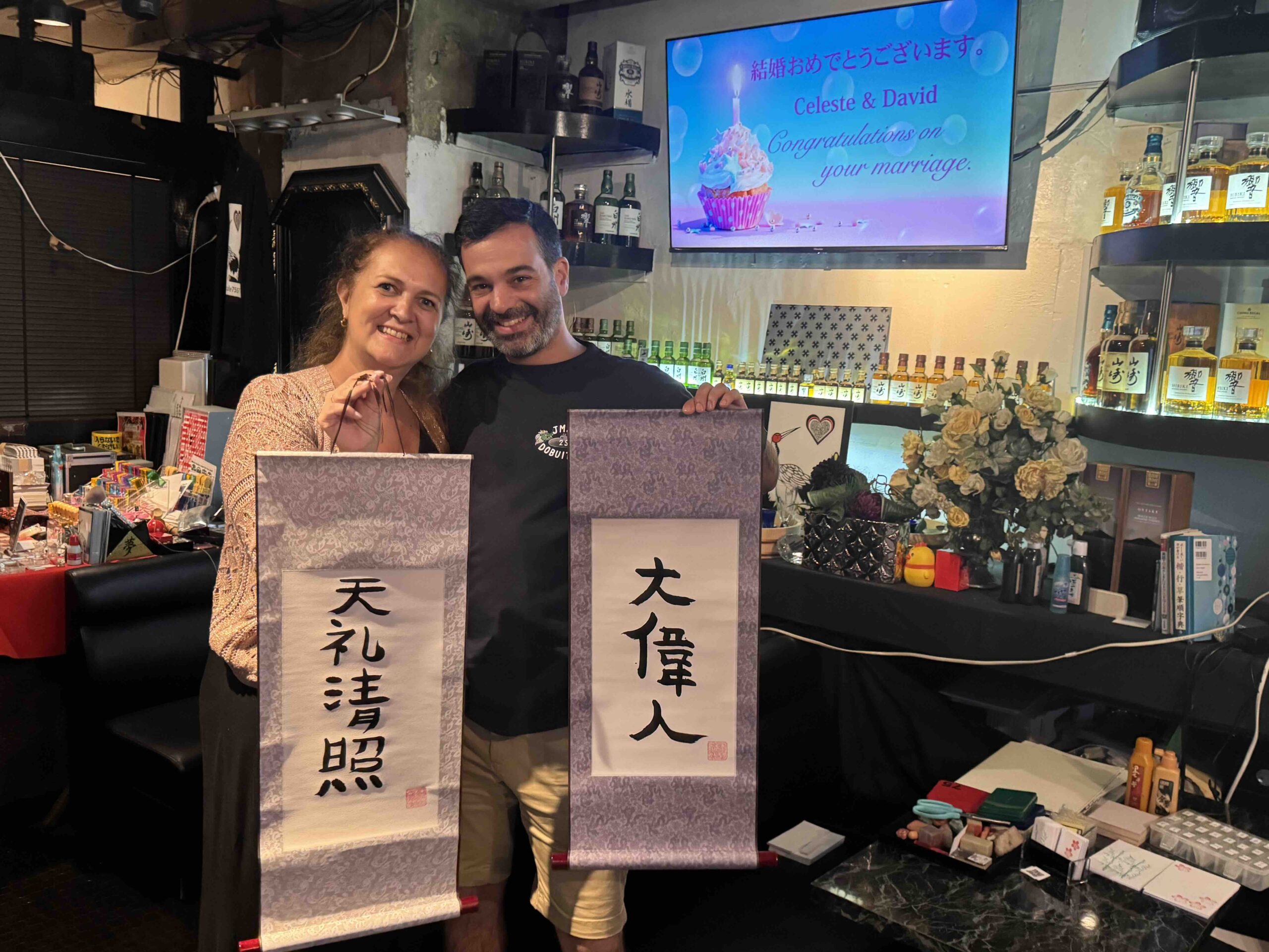 shodocafe7557 wedding gift calligraphy kanji celeste david roppongi scaled Newlyweds Celeste and David during their honeymoon at Shodocafe7557 in Roppongi, Tokyo, holding their personalized kanji calligraphy scrolls as a surprise wedding gift.