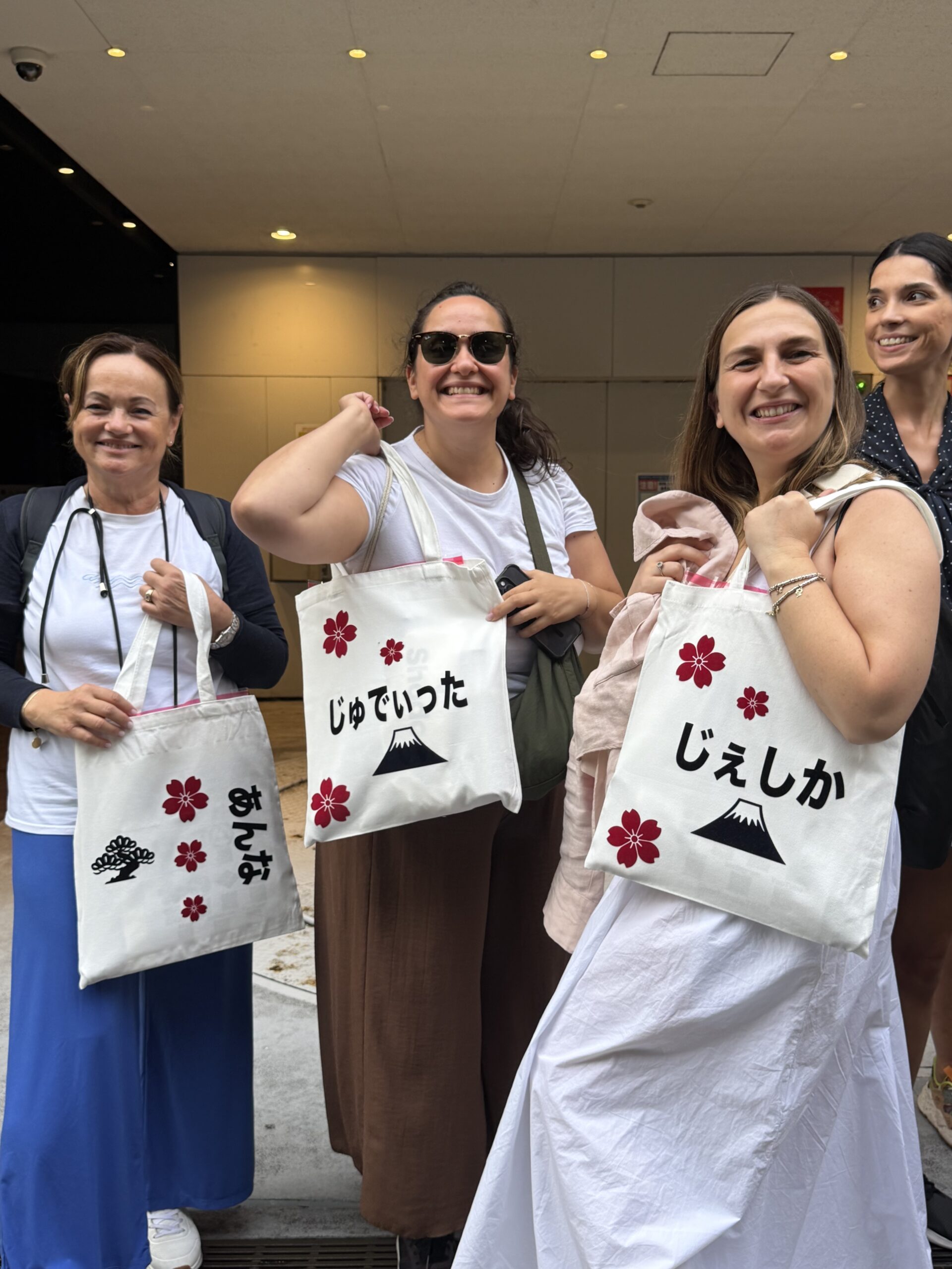 group hiragana name tote bag shodocafe7557 tokyo scaled Guests holding personalized Hiragana name tote bags after a private group Japanese calligraphy experience at Shodocafe7557 in Tokyo.