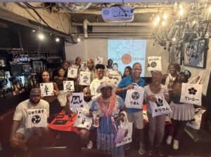 private group japanese calligraphy experience tokyo Private group enjoying a Japanese calligraphy experience in Tokyo and holding their handmade Kanji artwork at Shodocafe7557 in Roppongi.